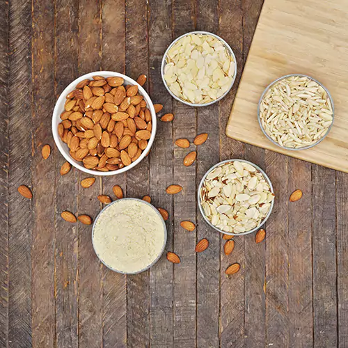 Above shot of roasted almonds, shaved almonds, almond flour, almond snippets