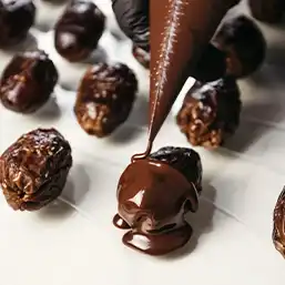 Nuts stuffed prunes coated with chocolate