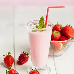 A tall glass of strawberry milk made with fresh strawberries