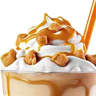 an ice cold beverage topped with whipped cream, crunchy pieces of honeycomb and caramel syrup drizzle.